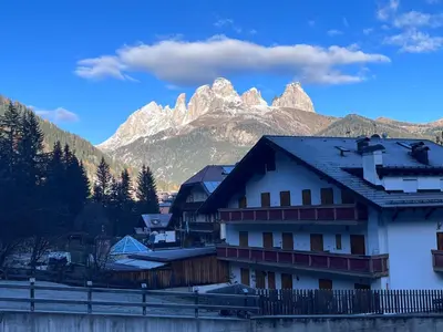 a building with a mountain in the background at Sellaronda - Ciampac Experience in Alba di Canazei
