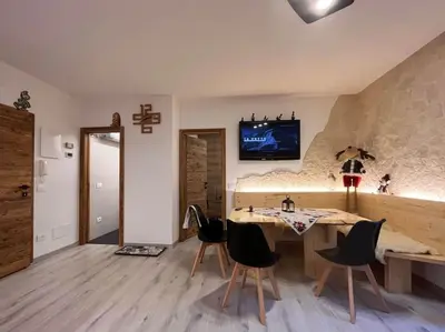 a dining room with a table and chairs and a tv at Sellaronda - Ciampac Experience in Alba di Canazei