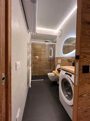 a bathroom with a toilet and a washing machine at Sellaronda - Ciampac Experience in Alba di Canazei