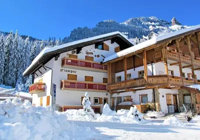 a large building with snow on the ground at Sellaronda - Ciampac Experience in Alba di Canazei