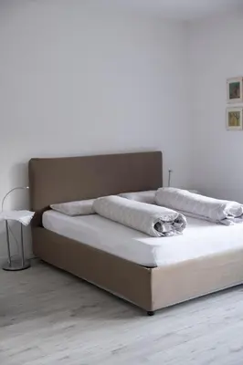 a bed with two pillows on top of it at City Apartments Portico in Merano