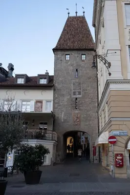 a large stone building with a gate in a street at City Apartments Portico in Merano