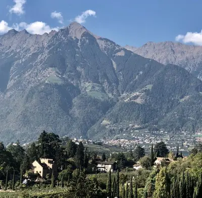 a mountain view of a town in front of a city at City Apartments Portico in Merano