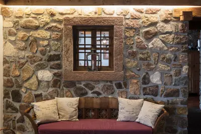a man sitting on a couch talking on a cell phone at Hotel Los Andes in Castello di Fiemme