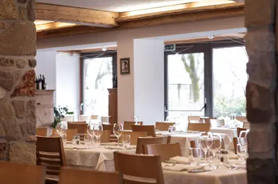a restaurant with tables and chairs and a piano at Hotel Los Andes in Castello di Fiemme