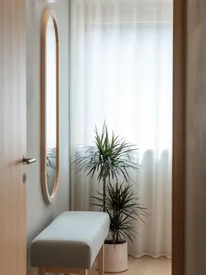 a room with a stool and a mirror and a window at Dianthus Apartment in Lana