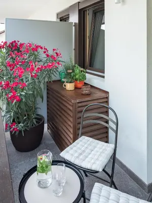 a patio with a table and a chair and flowers at Dianthus Apartment in Lana