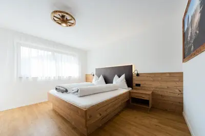 a bedroom with a bed with a wooden wall at Lüch de Corona in Frena