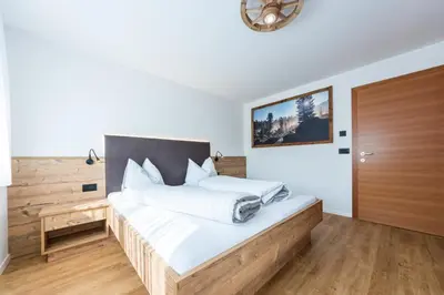 a bedroom with a large bed with a wooden headboard at Lüch de Corona in Frena