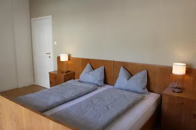 a bed with two blue pillows on top of it at Elina Apartment in Merano