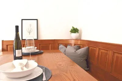 a wooden table with a bottle of wine and a glass at Elina Apartment in Merano