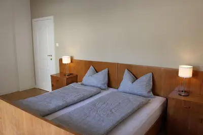 a bed with two blue pillows on top of it at Elina Apartment in Merano