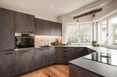 a kitchen with gray cabinets and a counter top at Dolomites Alpin Penthouse, 90qm, privat Sauna - privat Whirlpool in Mühlbach