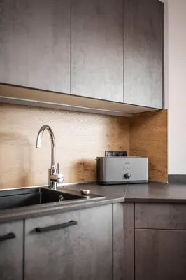 a kitchen with a sink and a microwave at Dolomites Alpin Penthouse, 90qm, privat Sauna - privat Whirlpool in Mühlbach