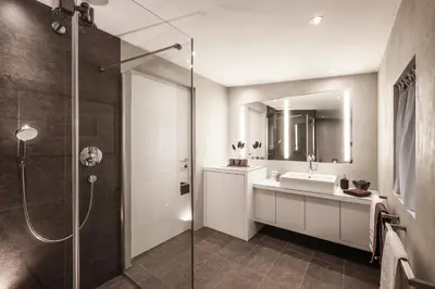 a bathroom with a shower and a sink and a mirror at Dolomites Alpin Penthouse, 90qm, privat Sauna - privat Whirlpool in Mühlbach