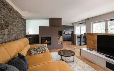 a living room with a couch and a fireplace at Dolomites Alpin Penthouse, 90qm, privat Sauna - privat Whirlpool in Mühlbach