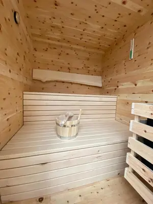 a wooden sauna with a bucket in it at Dolomites Alpin Penthouse, 90qm, privat Sauna - privat Whirlpool in Mühlbach
