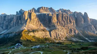 an aerial view of a mountain with a village in front at Alpin Hotel & Restaurant Frara in Selva di Val Gardena