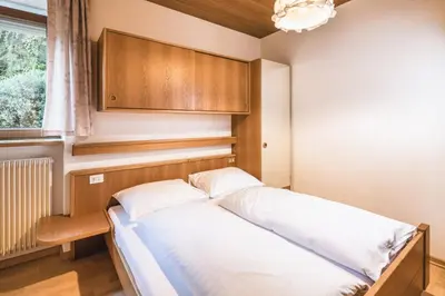 a small bedroom with a bed and a window at Apartments Chalet Zirm in Santa Cristina in Val Gardena