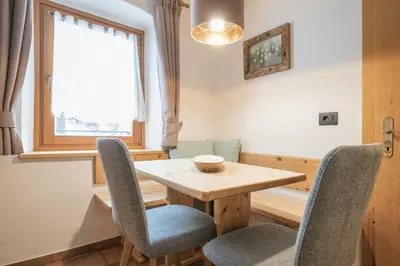 a dining room with a wooden table and chairs at Apartments Carmen in Ortisei