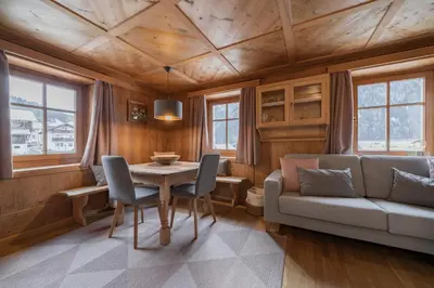 a dining room with a table and chairs and a couch at Apartments Carmen in Ortisei