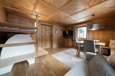 a living room with a bunk bed and a table at Apartments Carmen in Ortisei