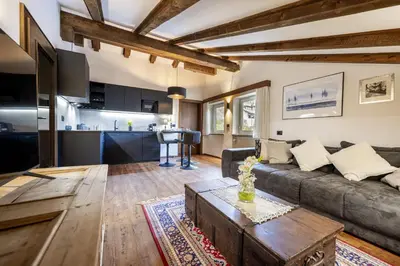 a bedroom with a large bed and a chair at Apartments Raphael in Ortisei