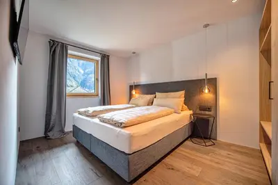 a bedroom with a large bed and a window at Apartments Elmarino in Ortisei