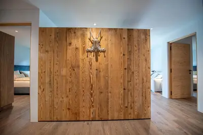 a room with a wooden wall with a chandelier on it at Apartments Elmarino in Ortisei