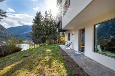a house with a view of a field and mountains at Apartments Elmarino in Ortisei