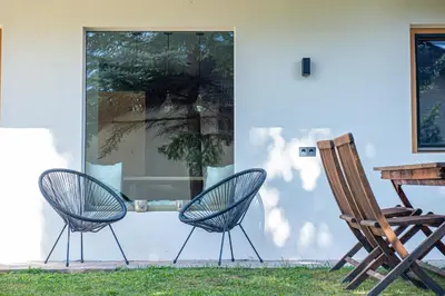 two chairs and a table in front of a house at Apartments Elmarino in Ortisei