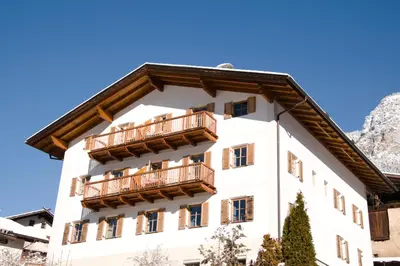 a building with balconies on it with mountains in the background at Messner Hof in Tires