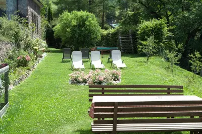 a group of benches sitting in the grass with flowers at Messner Hof in Tires