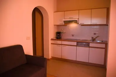 a kitchen with white cabinets and a couch in a room at Messner Hof in Tires