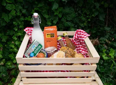 a wooden crate filled with food and a bottle of milk at Messner Hof in Tires
