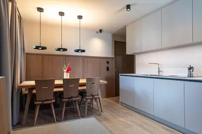an open kitchen with a wooden table and chairs at Apartments Am Platzl Living in Laion