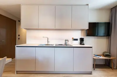 a kitchen with white cabinets and a sink at Apartments Am Platzl Living in Laion