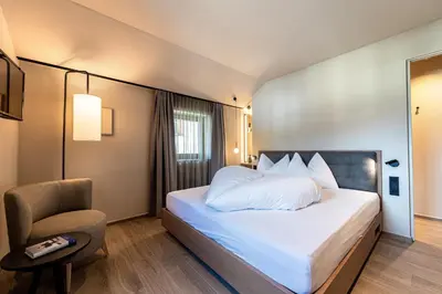 a hotel room with a bed and a chair at Apartments Am Platzl Living in Laion