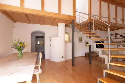 a room with a table and a spiral staircase at Charmantes Ferienhaus in Eppan, Südtirol, ganzes Haus nahe Montiggler Badeseen und Bozen in Appiano sulla Strada del Vino