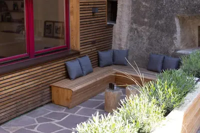 a wooden bench with blue pillows on a building at Charmantes Ferienhaus in Eppan, Südtirol, ganzes Haus nahe Montiggler Badeseen und Bozen in Appiano sulla Strada del Vino