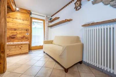 a living room with a chair and a radiator at Cesa Anna in Campitello di Fassa