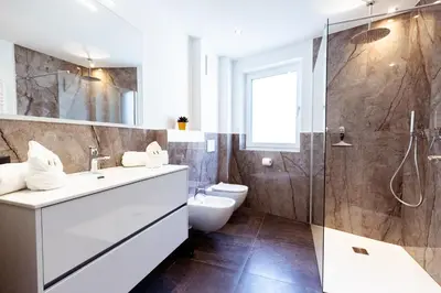 a bathroom with a sink and a toilet and a shower at Ramoser Living Apartments in San Martino