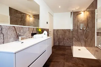 a bathroom with a sink and a shower at Ramoser Living Apartments in San Martino