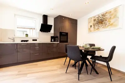 a kitchen and dining room with a table and chairs at Ramoser Living Apartments in San Martino