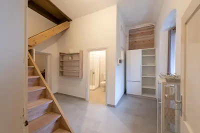 a hallway with stairs leading to a bathroom at der Paterhof- wohnen in historischen Mauern in Pianizza di Sopra