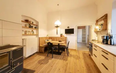 a kitchen with a table and chairs in a room at der Paterhof- wohnen in historischen Mauern in Pianizza di Sopra
