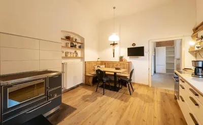 a kitchen with a table and a dining room at der Paterhof- wohnen in historischen Mauern in Pianizza di Sopra