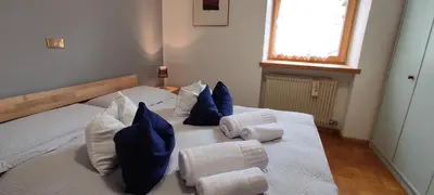 a bedroom with two beds with towels and pillows at Ai Grisi in Cavalese