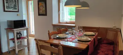 a dining room with a table with chairs and a table at Ai Grisi in Cavalese