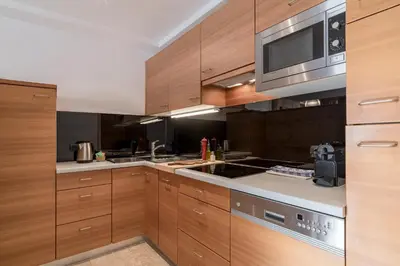 a kitchen with wooden cabinets and a stove top oven at Cësa Marmolada 1318 in Ortisei